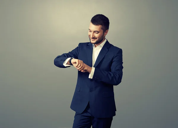 Hombre de negocios mirando su reloj sobre la oscuridad — Foto de Stock