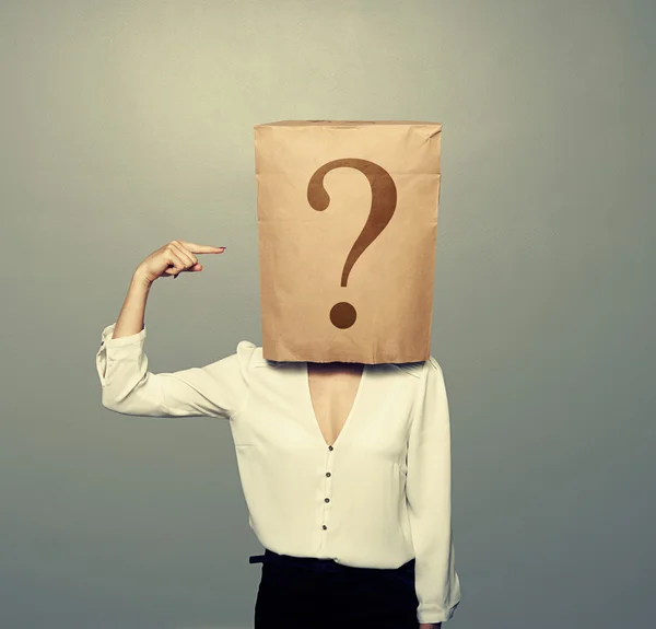Woman with paper bag pointing at question — Stock Photo, Image