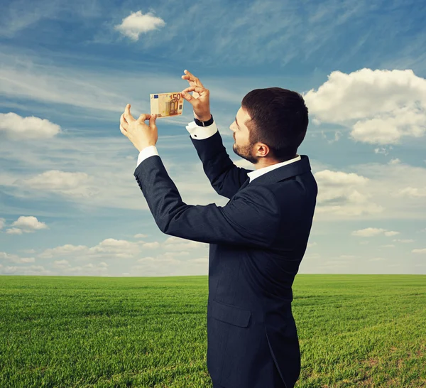 Hombre examinando el billete al aire libre —  Fotos de Stock