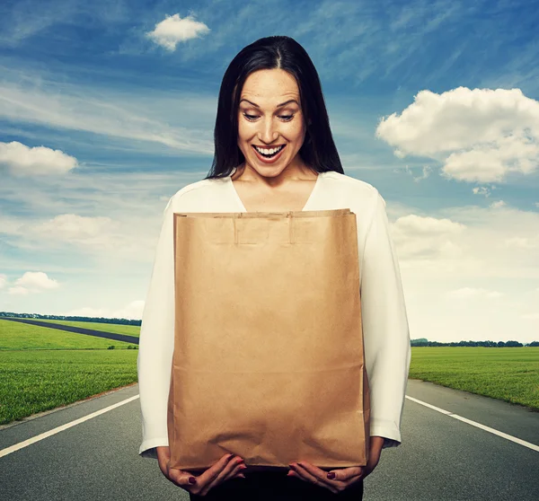 Mujer mirando en la bolsa de papel —  Fotos de Stock