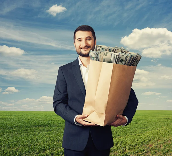 Hombre exitoso y guapo sosteniendo bolsa de papel — Foto de Stock