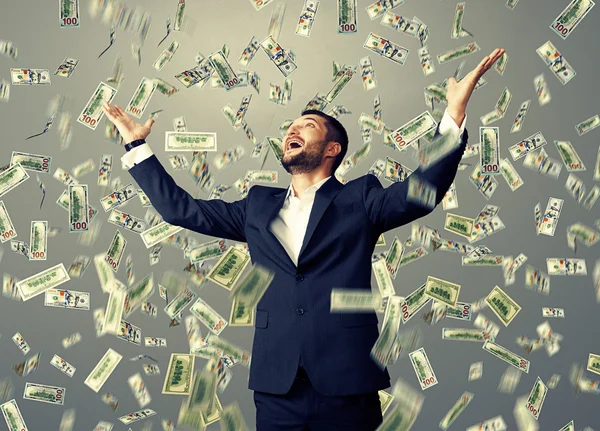 Man standing under dollar 's rain — стоковое фото