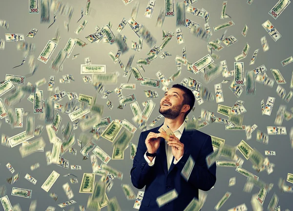 Man standing under dollar 's rain — стоковое фото