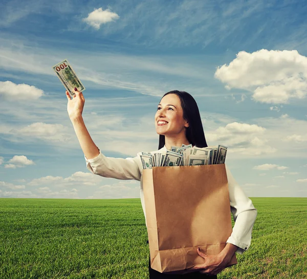 Frau schaut sich hundert Dollar an — Stockfoto