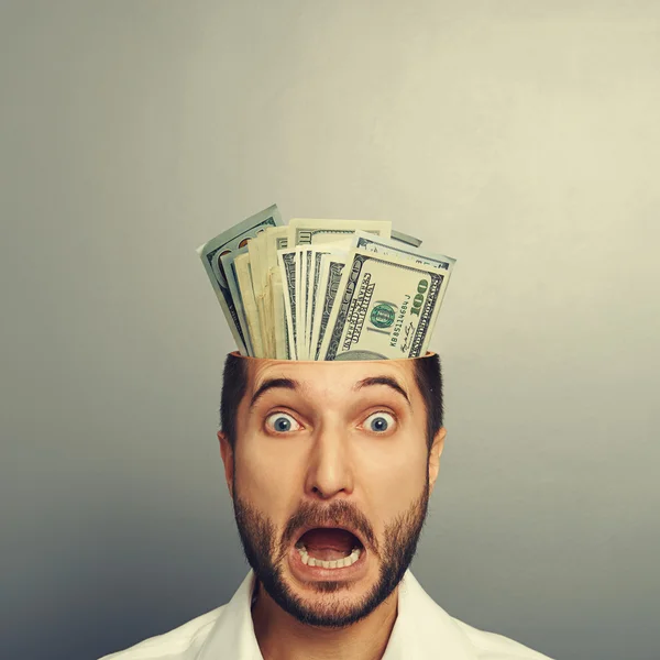 Shocked young businessman with money — Stock Photo, Image