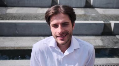 açık havada gülümseyerek mutlu bir genç adam