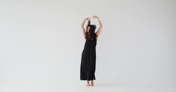 Felice giovane donna in abito nero saltando e ballando — Video Stock