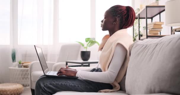 Frau arbeitet am Laptop und sitzt auf Sofa — Stockvideo