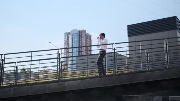 Empresario hablando por teléfono móvil mientras camina en pendiente — Vídeos de Stock