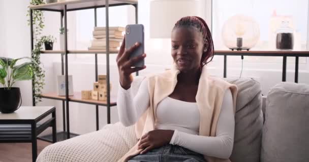 Счастливая женщина снимает видео с помощью мобильного телефона дома — стоковое видео