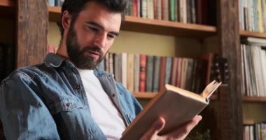 Evde kitap okuyan bir adam.
