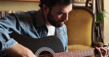 Evde gitar çalan adam.