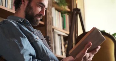 Evde kitap okuyan bir adam.