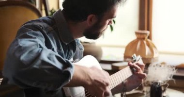 Evde gitar çalan adam.