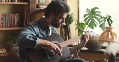 Evde gitar çalan adam.