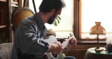 Evde gitar çalan adam.