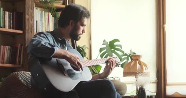Seorang pria bermain gitar di rumah — Stok Video