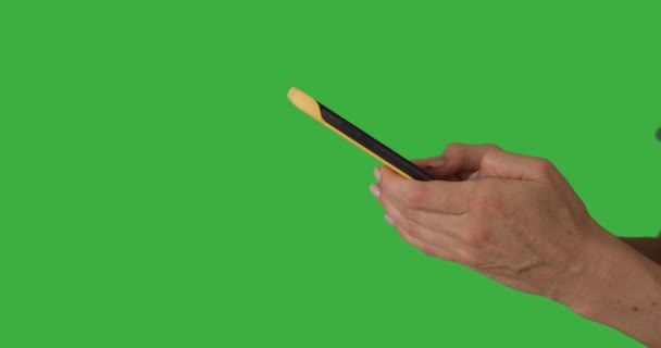 녹색 화면에서 휴대 전화를 사용하여 손으로 문자 메시지를 보내다 — 비디오