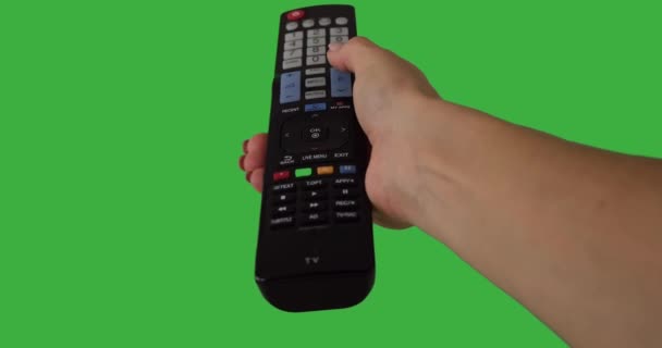Hand pressing remote control button over green background — Stock Video