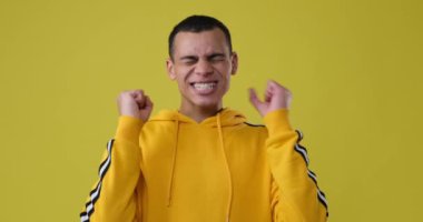 Sarı arka planda zaferi kutlayan adam