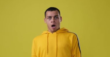 Şok olmuş adam sarı arka planı reddediyor.