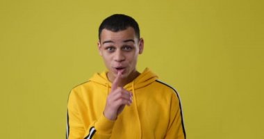 Dudaklarında parmak olan bir adam. 