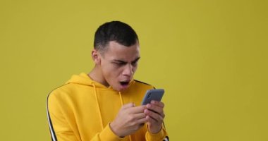 Adam gülüyor ve cep telefonu kullanıyor.