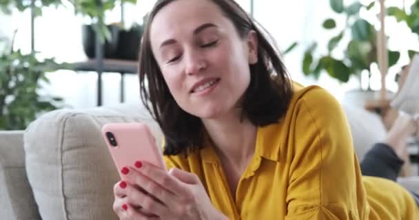 Mujer usando teléfono móvil y cantando canciones en casa — Vídeo de stock