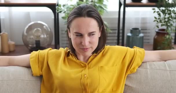Женщина танцует на диване дома — стоковое видео