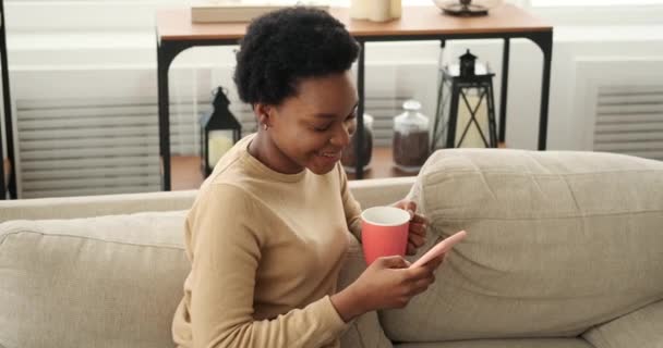 Vrouw met mobiele telefoon en het drinken van koffie — Stockvideo