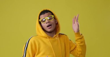 Sarı arka planda dans eden mutlu adam