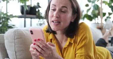 Cep telefonu kullanan ve evde şarkı söyleyen bir kadın