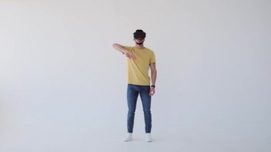 Kulaklık takan ve el kol hareketi yapan bir adam.