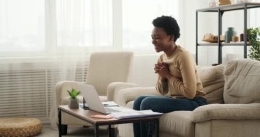 Laptop kullanan bir kadın kötü haber alınca üzülüyor.