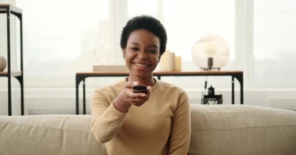 Femme heureuse changer de canaux assis sur le canapé — Video