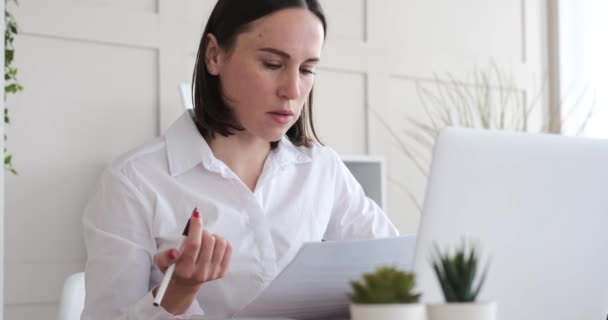 Empresária confusa fazendo papelada e usando laptop no escritório — Vídeo de Stock