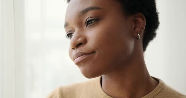 Droevige vrouw die door het raam kijkt — Stockvideo