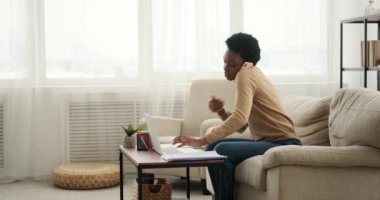 Dizüstü bilgisayar kullanan ve cep telefonuyla konuşan kadın.