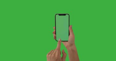 Yeşil arkaplanda dokunmatik ekranlı eller çalışan cep telefonu