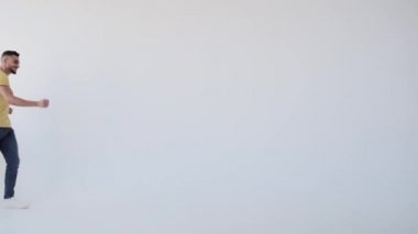 Neşeli adam yürürken ve dans ederken el sallıyor