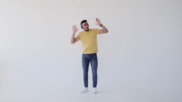 Молодий чоловік танцює, слухаючи музику на навушниках — стокове відео