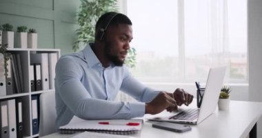 Afrikalı Amerikalı iş adamı müzik dinliyor ve çalışırken eğleniyor.