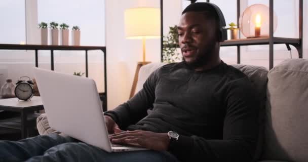 Uomo ascoltare musica sulle cuffie durante l'utilizzo di laptop — Video Stock