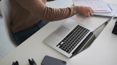 Ofiste dizüstü bilgisayarda daktilo kullanan bir işadamı.