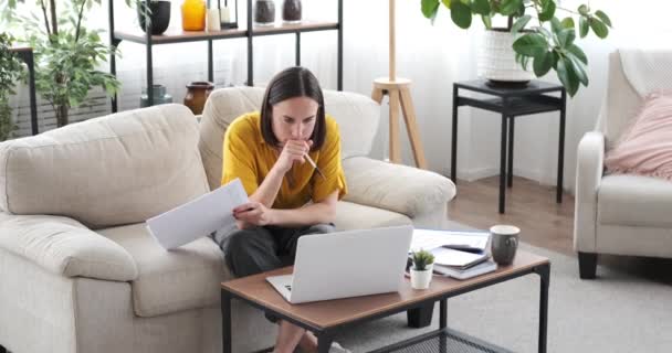 Frau benutzt Laptop und Handy bei der Arbeit zu Hause — Stockvideo