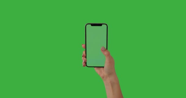 Handbediende mobiele telefoon met duim op groene achtergrond — Stockvideo