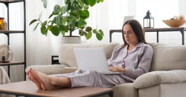 Evde dizüstü bilgisayarda çalışan bir kadın.