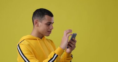 Adam gülüyor ve cep telefonu kullanıyor.