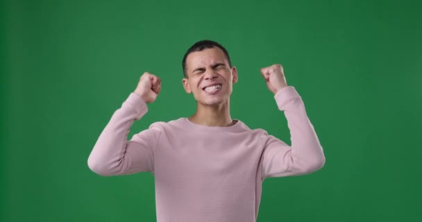 Man celebrating victory over green background — Stock Video