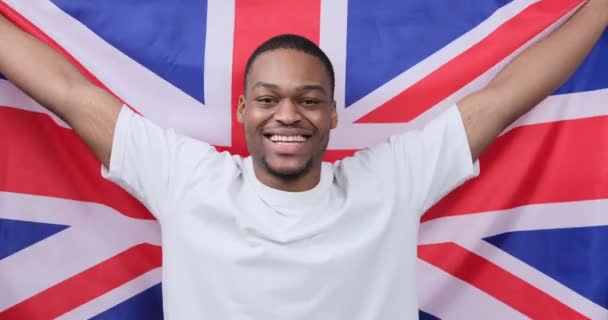 Mann feiert und hält Flagge von Großbritannien — Stockvideo